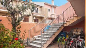 A staircase leading to a building with a metal railing, a tree, and several bicycles parked outside. - Holiday Apartment ‘Casa Vacanze Pula' with Balcony & Terrace (Pula)