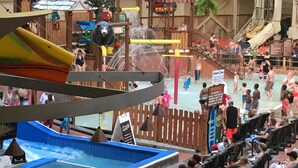 A water park with various water slides and pools, surrounded by wooden structures and a wooden fence. - Wyndham Great Smokies Lodge at Wilderness water park(s) included (Sevierville)