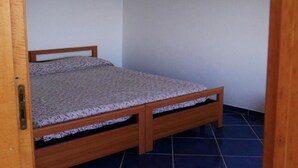 A small, single-bed room with a wooden frame and a patterned mattress. - Residenze Cutrì Holiday Home Cilento Bilo 2 (Pisciotta)