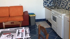 A compact kitchen with a stove, sink, and a tiled backsplash. - Residenze Cutrì Holiday Home Cilento Bilo 2 (Pisciotta)