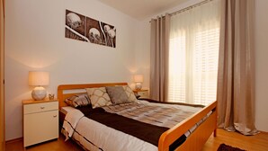 A neatly arranged bedroom with a wooden bed, two bedside tables with lamps, a nightstand, and a wall-mounted artwork. - HOUSE  DRAGOJEVIC (Vela Luka)
