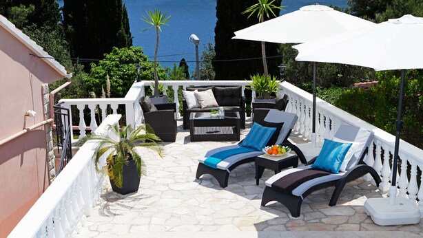 A sunlit outdoor seating area with a pool, white railings, and potted plants. - HOUSE  DRAGOJEVIC (Vela Luka)