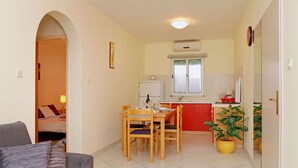 A compact living space with a dining area, kitchenette, and a visible bedroom. - HOUSE  DRAGOJEVIC (Vela Luka)
