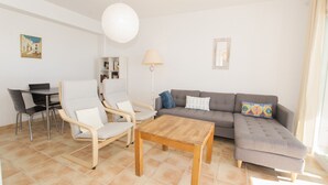 A living room with a sofa, chairs, a coffee table, a lamp, and a painting on the wall. - A28 EDIFICIO RIO 4º 14 (Calpe)