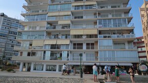 A multi-story building with balconies, a ground-level shop, and a visible sign for a restaurant. - A28 EDIFICIO RIO 4º 14 (Calpe)