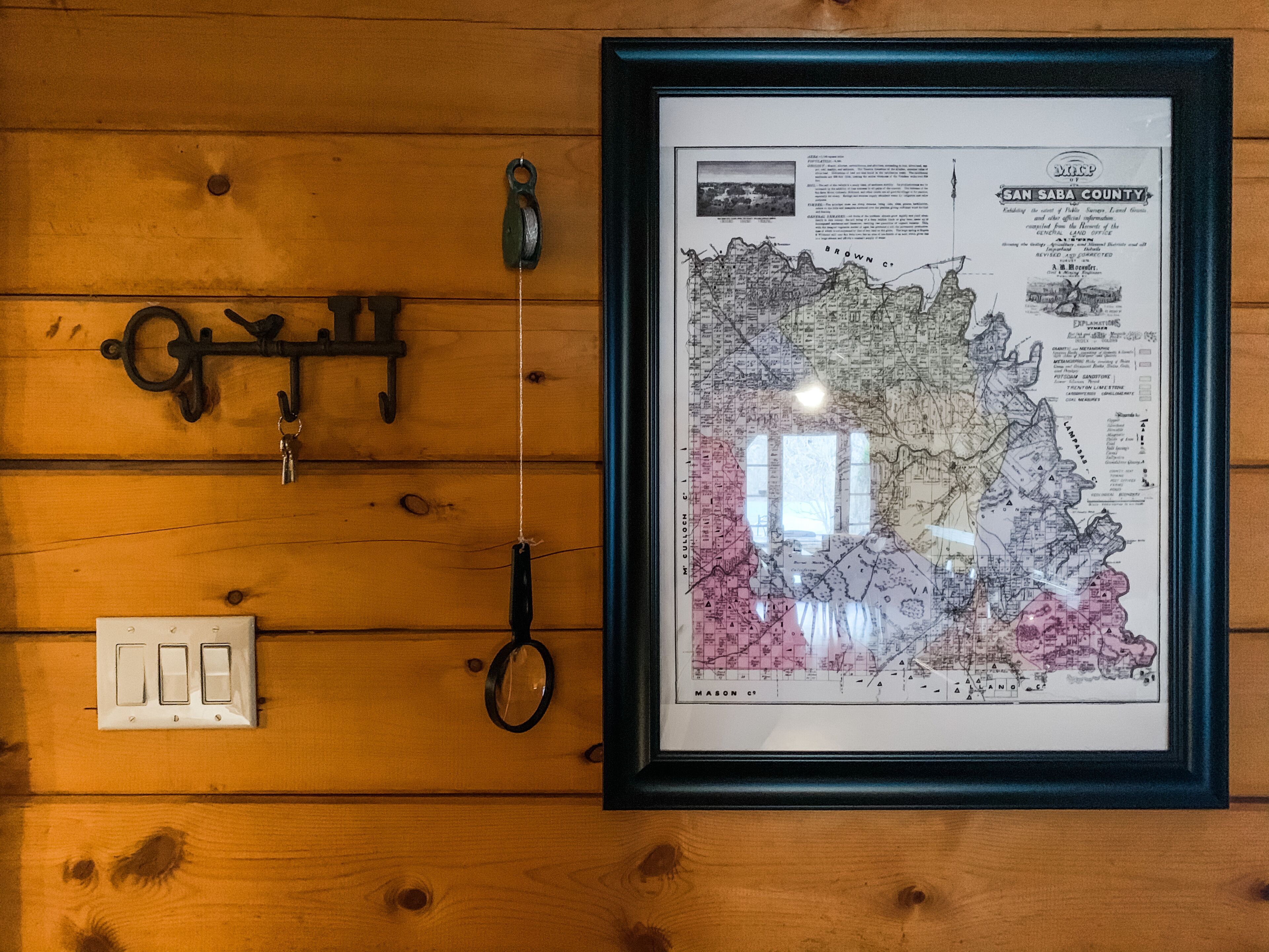 A framed map of San Saba County with a wooden wall background.
