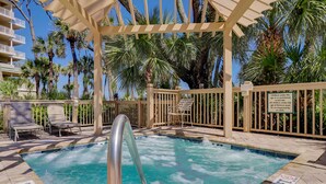 A pool area with a hot tub, lounge chairs, and a wooden pergola. - 5105 Hampton Place - Amazing Views (Hilton Head Island)