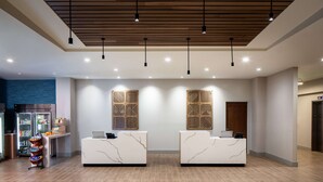 A reception area with marble reception desks, a wooden ceiling, and a wall-mounted refrigerator. - Hyatt House North Scottsdale (Scottsdale)