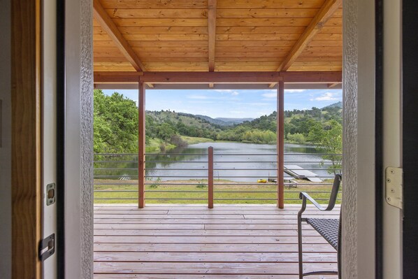 A wooden deck with a view of a lake and hills. - Modern Cabin on Private Lake: Gateway to the Sequoias (Springville)