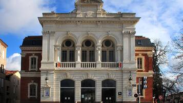 Un edificio clásico con entrada central, ventanas en arco y un balcón con barandilla.