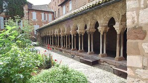 A courtyard with a row of arches and a stone building in the background. - Appart Hôtel Albi (Albi)