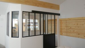 A room with a wooden ceiling, a black-framed window, and a view of the outside. - Appart Hôtel Albi (Albi)