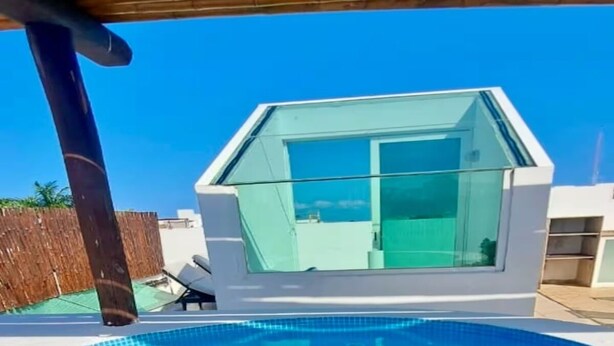 Ein Swimmingpool mit einer glatten, blauen Wasseroberfläche, umgeben von einer weißen Terrasse.