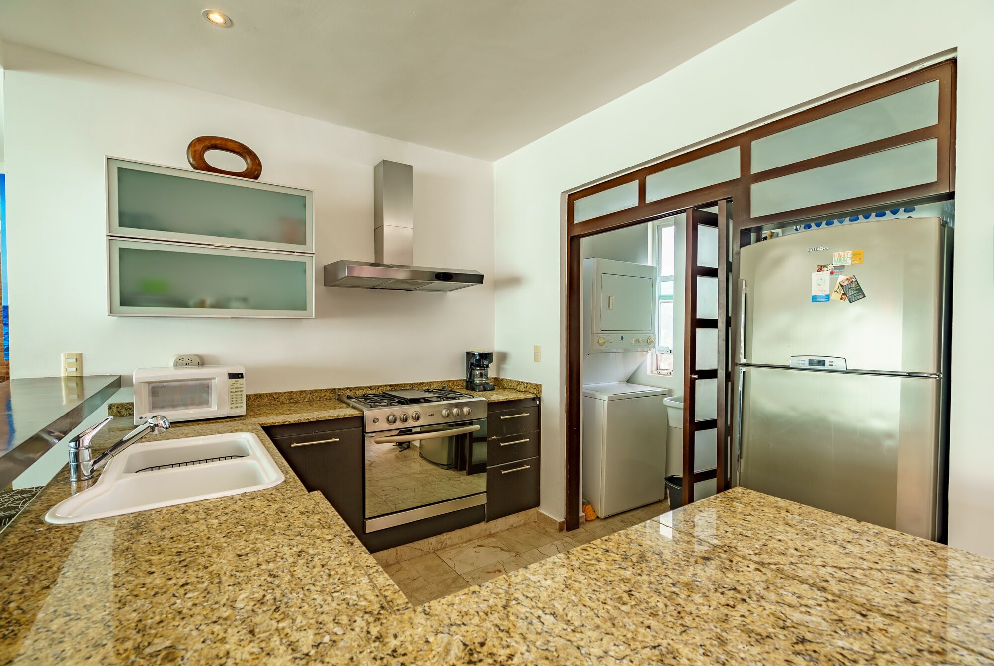Una cucina moderna con piani in granito, elettrodomestici in acciaio inossidabile e forno integrato.