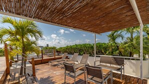 A wooden deck with lounge chairs and a pergola. - Downtown Playa close 5th Av Rooftop Pool (Playa del Carmen)