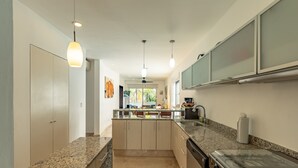 A modern kitchen with granite countertops, a built-in stove, and a central island. - Downtown Playa close 5th Av Rooftop Pool (Playa del Carmen)