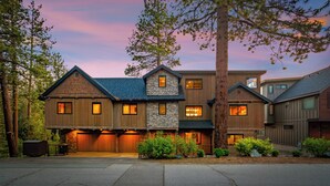 A multi-story house with a stone facade, wooden trim, and a garage.
