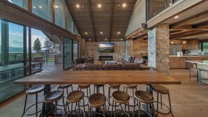 A spacious kitchen with a large island, bar stools, and a stone accent wall.