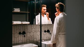 A modern bathroom with a large mirror, two sinks, and a towel rack.