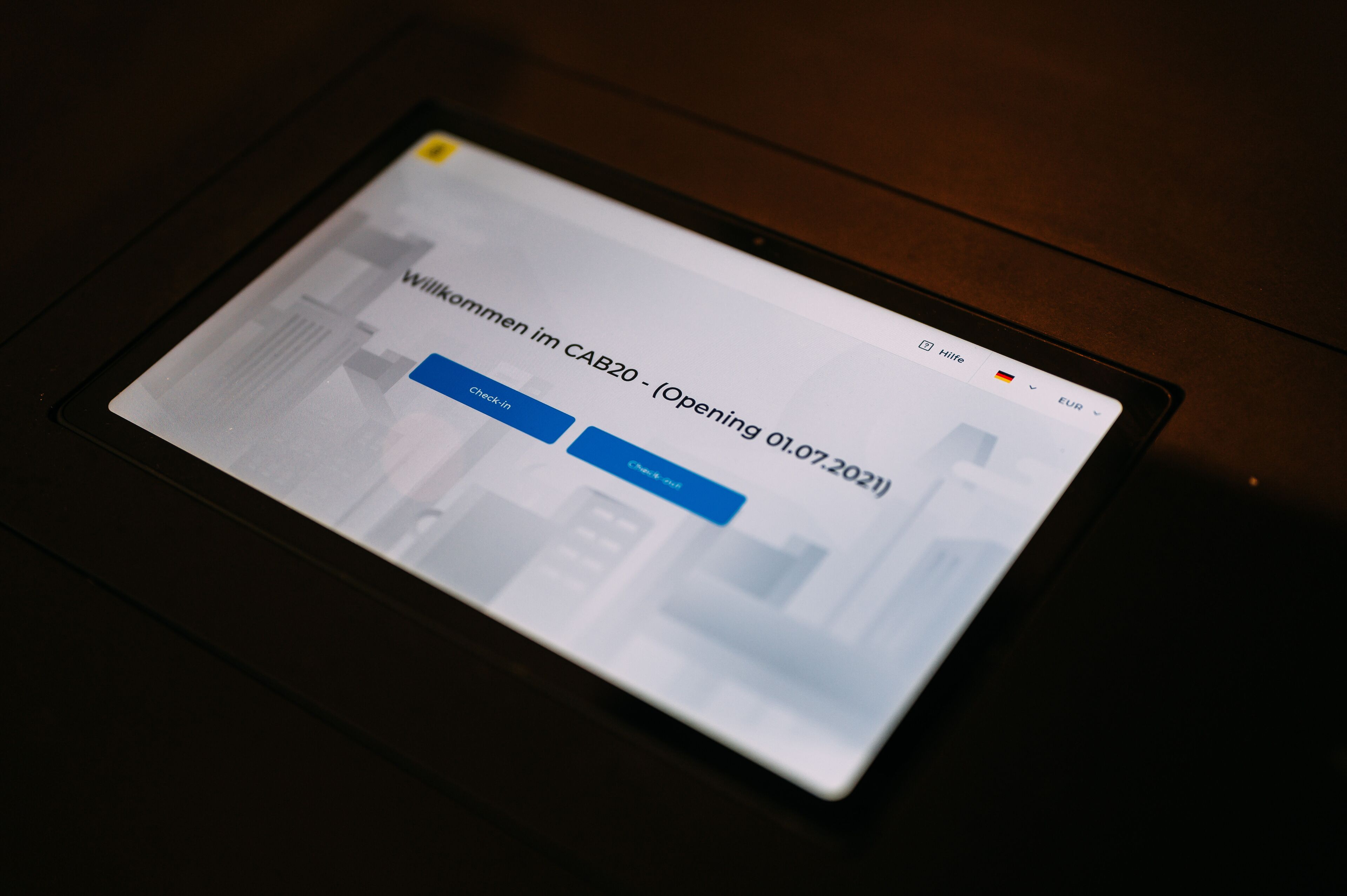 A tablet displaying a webpage with the text "Willkommen im CAB20 - (Opening 01.07.2021)".