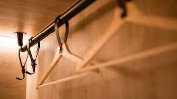 A close-up of a metal rack with hooks, likely for hanging items, against a wooden wall.
