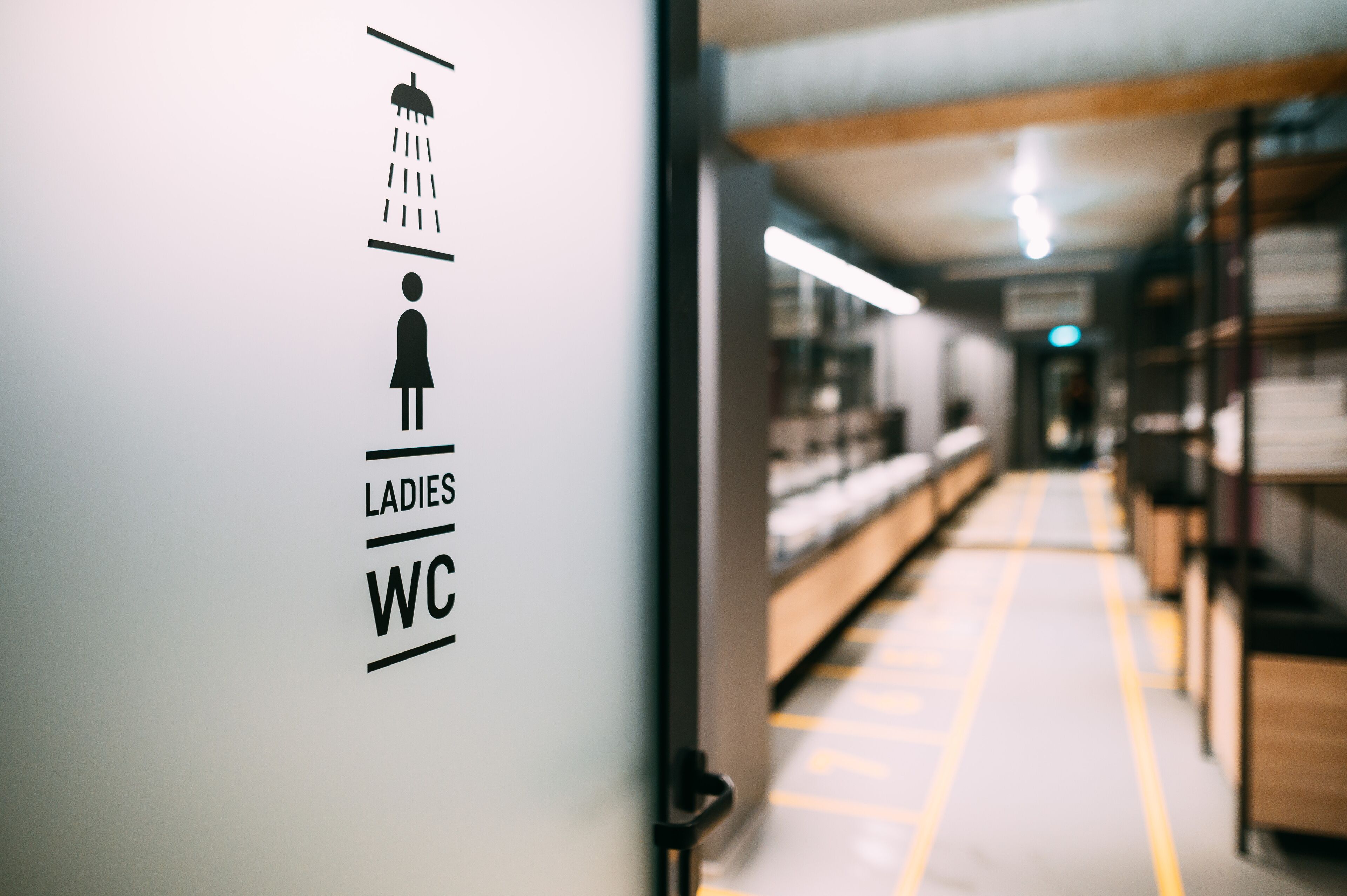 Un couloir avec un panneau indiquant les toilettes pour femmes.