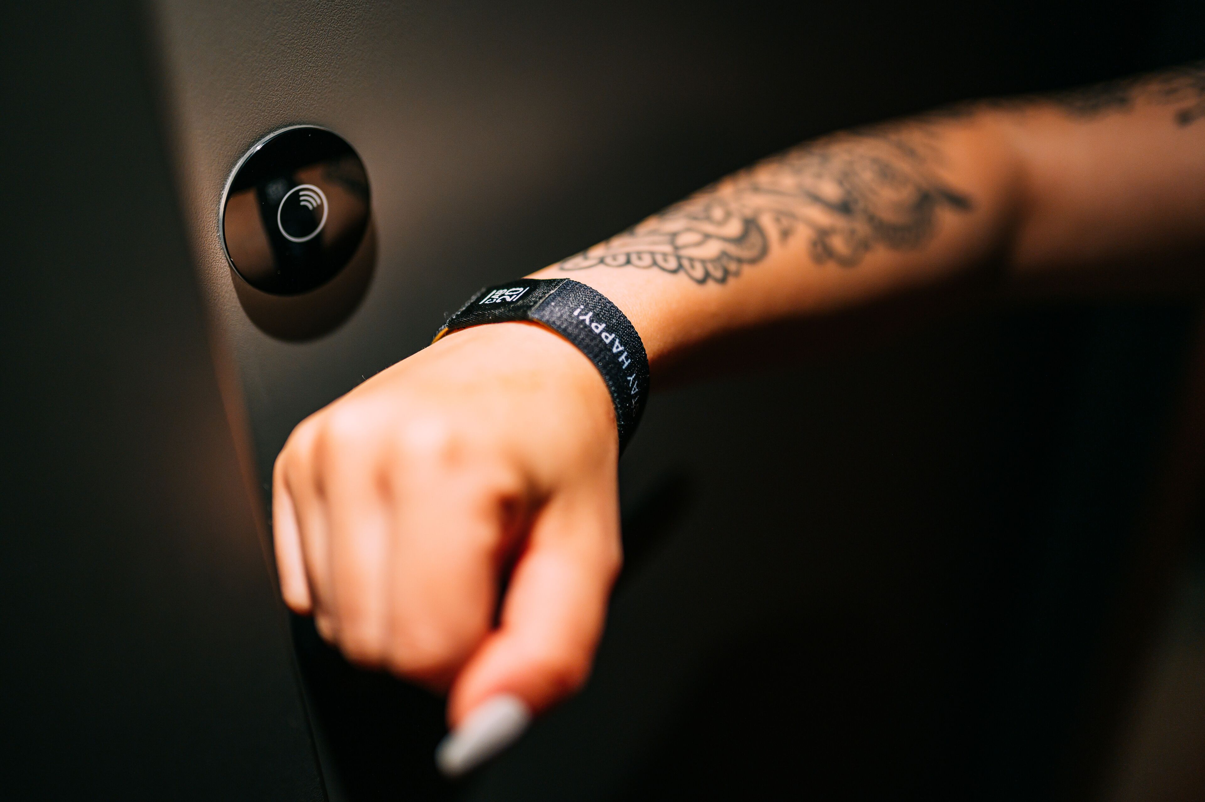 A hand reaching for a door handle.