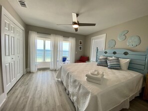 A bedroom with a bed, a ceiling fan, a view of the ocean, and a door leading to a balcony. - Best pool in the neighborhood! 4 bdrm/4.5 bath gulf front with huge pool. (Port St Joe)