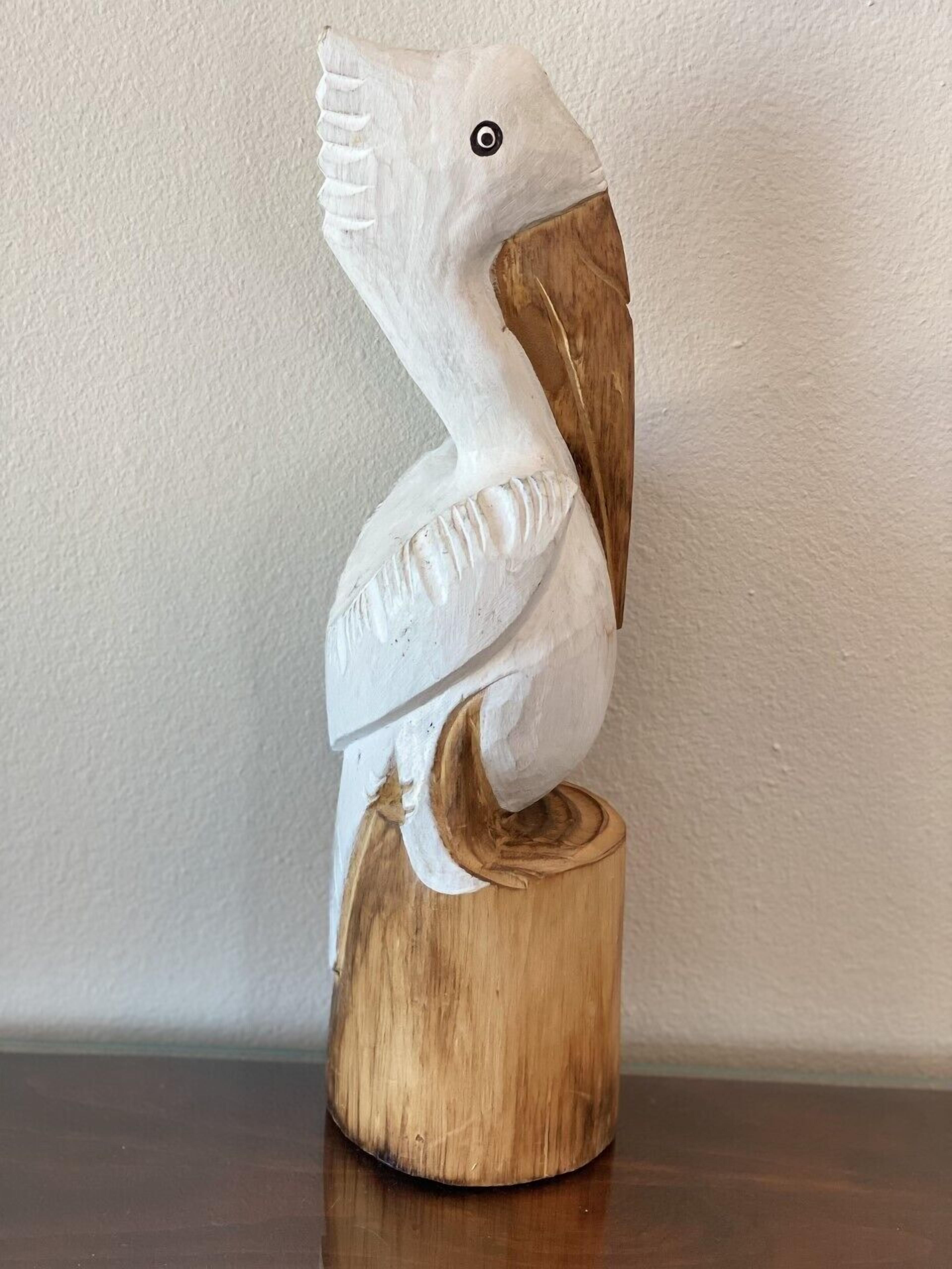 A wooden sculpture of a pelican.