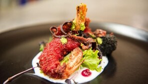 A dish with various components including a crispy item, greens, and a red sauce. - Gondwana Game Reserve (Mossel Bay)