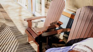 A wooden deck with two Adirondack chairs and a covered area. - Private & Secluded w/ Beautiful Views Sunsets ~Hot Tub (Gatlinburg)