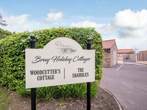 A sign for 'Bray Holiday Cottages' with 'Woodcutter's Cottage' and 'The Shamblers' listed.