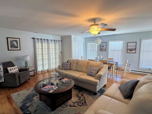 A living room with a sofa, coffee table, and a ceiling fan.