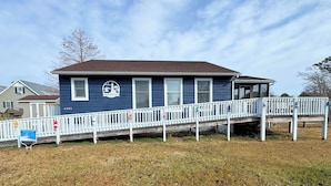 A two-story house with a blue exterior and a white porch. - Shucker's Tump -  pet friendly, Lg screened porch. LINENS AND TOWELS PROVIDED (Chincoteague)