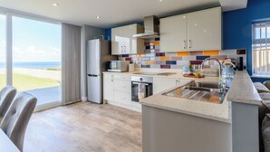 A modern kitchen with a large island, white cabinets, and colorful backsplash tiles. - 3 bedroom accommodation in Reighton Gap, near Filey (Reighton Gap, near Filey)