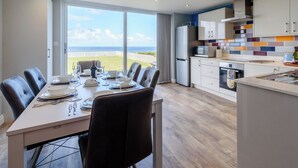 A modern kitchen with a large island, a dining area with a view of the ocean, and a spacious living area. - 3 bedroom accommodation in Reighton Gap, near Filey (Reighton Gap, near Filey)