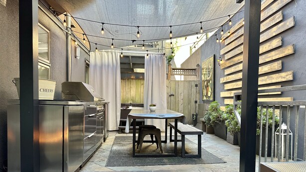 A modern outdoor patio with a fire pit, a dining table, and a grill. - Luxury Modern Unit on Market St - w/Private Patio - Hot tub, Fire Pit, Lounge + (SF)