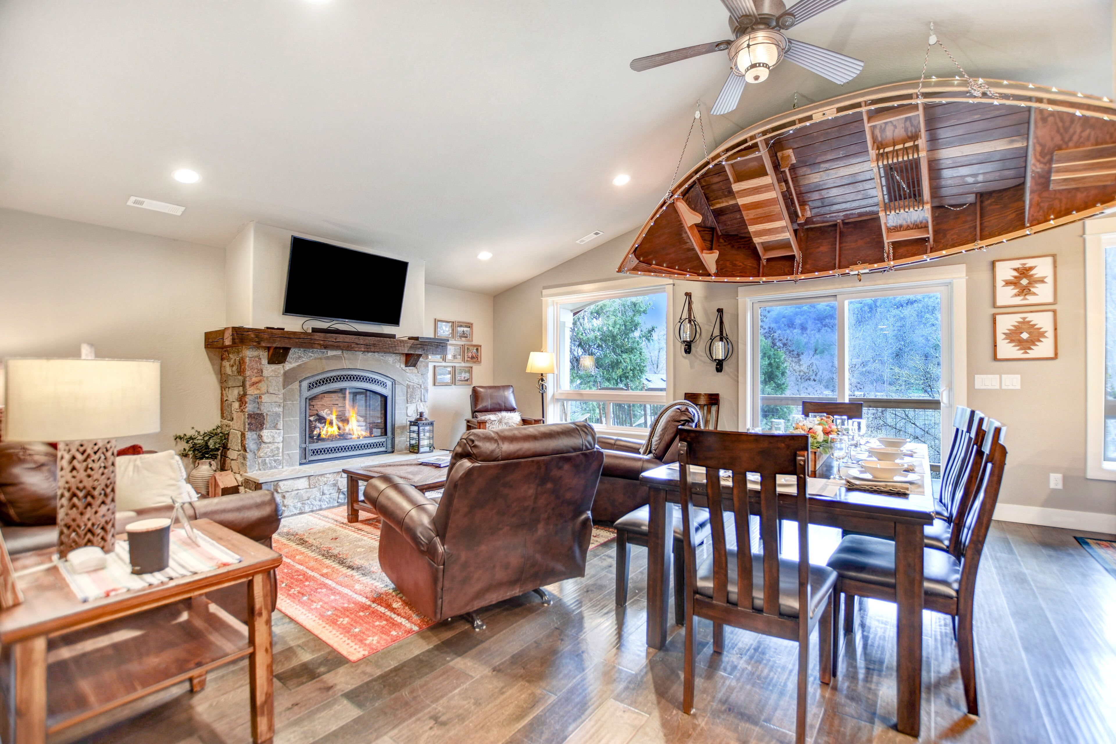 A spacious living room with a fireplace, leather furniture, and large windows.