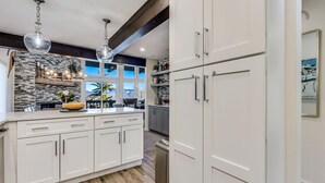 A modern kitchen with white cabinetry, a central island, and pendant lighting. - 🏔️Ski-In, Ski-Out~Hot Tub~Top Floor~Interlude 301🏔️ (Snowmass Village)