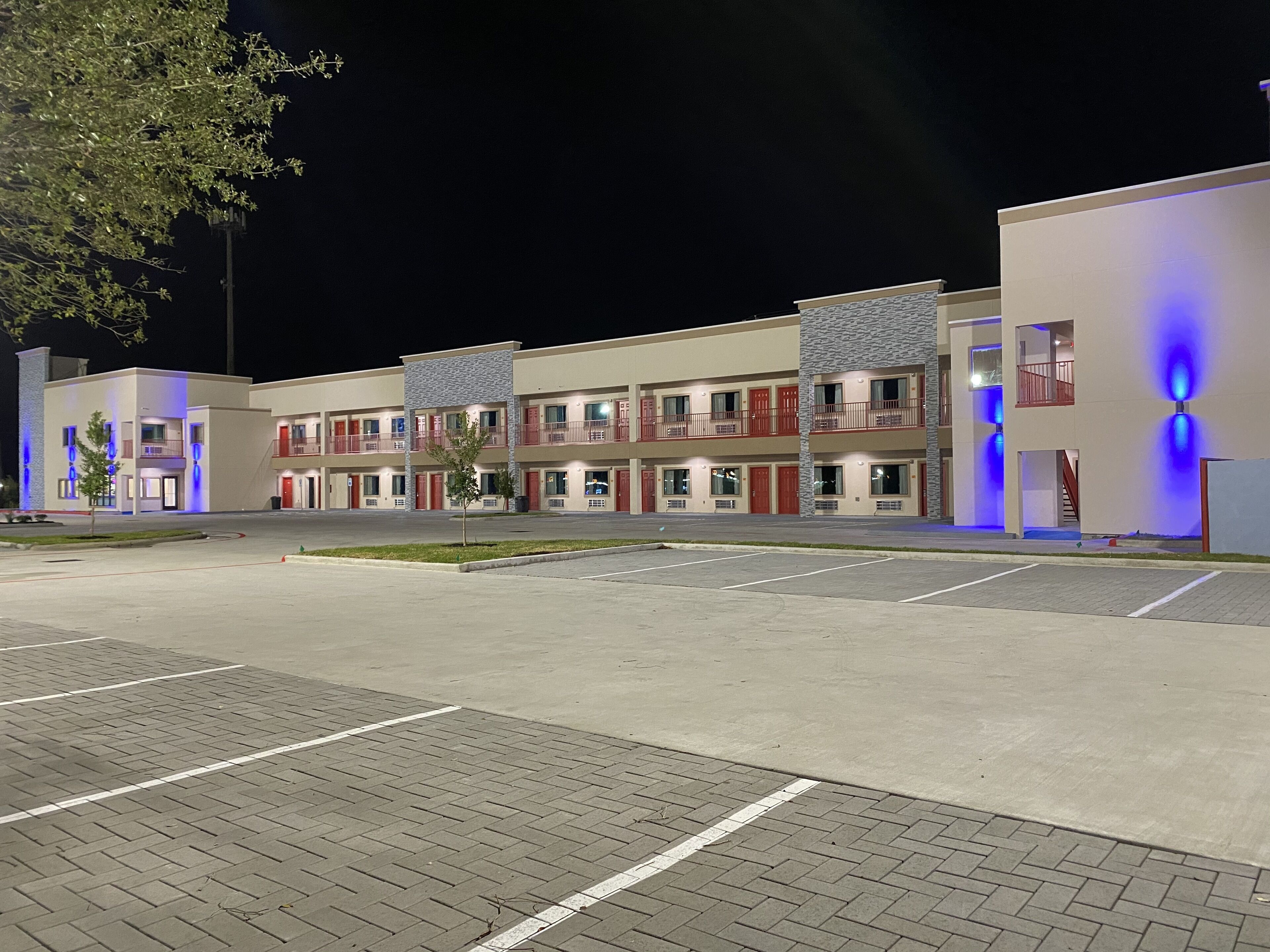 Ein mehrstöckiges Hotel mit Parkplatz davor.