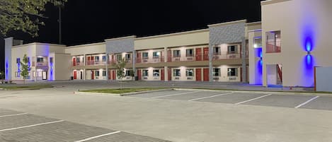 Ein mehrstöckiges Hotel mit Parkplatz davor.