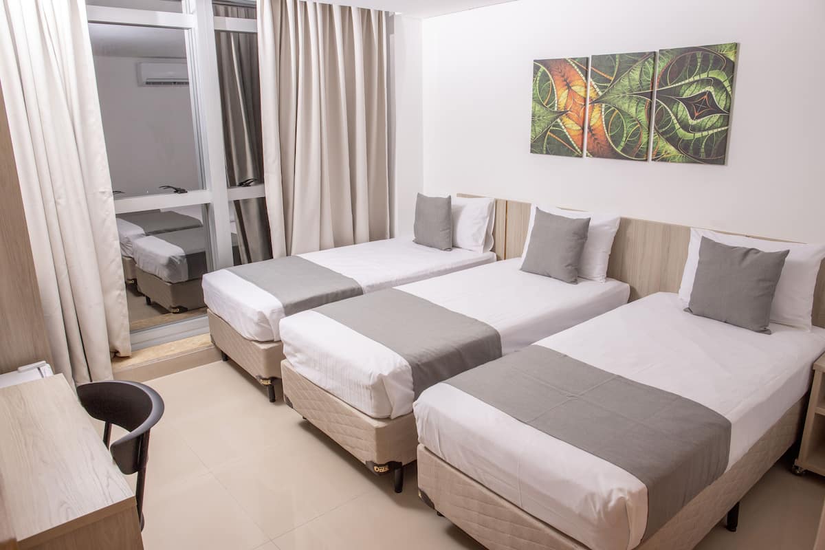 Ein Hotelzimmer mit zwei Einzelbetten, einem Schreibtisch und einem Stuhl.