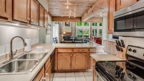 Una cocina moderna con armarios de madera, electrodomésticos de acero inoxidable y una isla central.