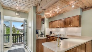 Una cocina moderna con armarios de madera, una isla grande y vistas al exterior.
