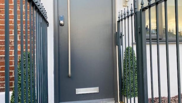 A modern grey door with a vertical handle, a small rectangular window below, and a number '71' on the wall to the right. - Townhouse Plus @ Lower Beth Street Stoke (Stoke-on-Trent)