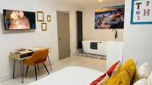 A modern hotel room with a bed, a desk, and a bathtub. - Townhouse Plus @ Lower Beth Street Stoke (Stoke-on-Trent)