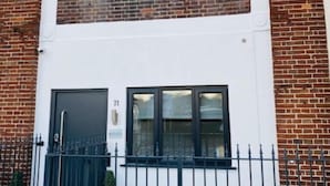 A two-story building with a white facade and brick accents. - Townhouse Plus @ Lower Beth Street Stoke (Stoke-on-Trent)