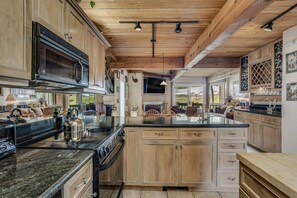 A spacious kitchen with wooden cabinets, a large island, and a built-in oven. - 🏔️Ski-In, Ski-Out Condo~Hot Tub~Interlude 209🏔️ (Snowmass Village)
