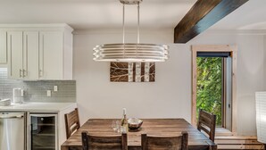 A modern kitchen with white cabinets, a built-in oven, and a dining area with a wooden table and chairs. - 🏔️Ski-in, Ski-out Condo~Hot Tub~Interlude 101🏔️ (Snowmass Village)