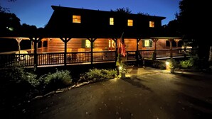 Una baita con portico, una bandiera e un interno ben illuminato.